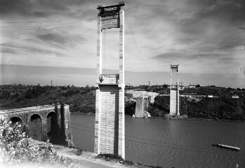 1 vue  - [La Roche-Bernard. Pont suspendu, vue depuis la rive droite des deux pylônes du pont (hauteur 84 m) avec, en arrière plan, les deux culées de l\'ancien pont en amont.]. (ouvre la visionneuse)