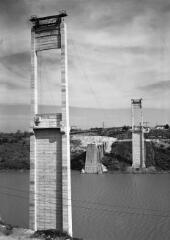 1 vue  - [La Roche-Bernard. Pont suspendu, vue depuis la rive droite des deux pylônes du pont (hauteur 84 m) avec, en arrière plan, une des deux culées de l\'ancien pont en amont.]. (ouvre la visionneuse)