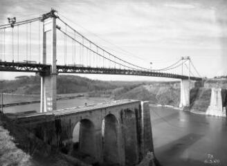 1 vue  - [La Roche-Bernard. Pont suspendu, vue depuis la rive gauche du pont avec, en premier plan, les deux culées de l\'ancien pont et, en arrière plan, le pont flottant.]. (ouvre la visionneuse)