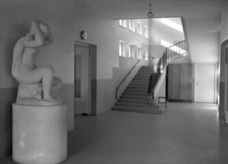 1 vue  - [Lorient, avenue Jean-Jaurès. École maternelle de Merville, vue intérieure d\'un couloir avec escalier avec, au premier plan, une sculpture.]. (ouvre la visionneuse)