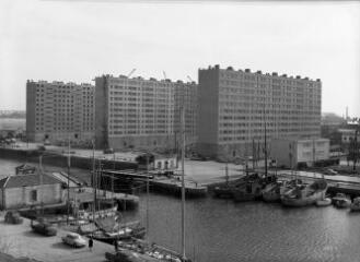 1 vue  - [Lorient, quai de Rohan. Barres d\'immeubles HLM en construction, les trois barres construites avec, au premier plan, le bassin à flot et la porte éclusière.]. (ouvre la visionneuse)