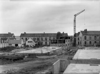 1 vue  - [Lorient, Kerolay. Groupe d\'immeubles collectifs, construction, vue d\' une dalle coulée avec, en arrière plan, et deux bâtiments terminés.]. (ouvre la visionneuse)
